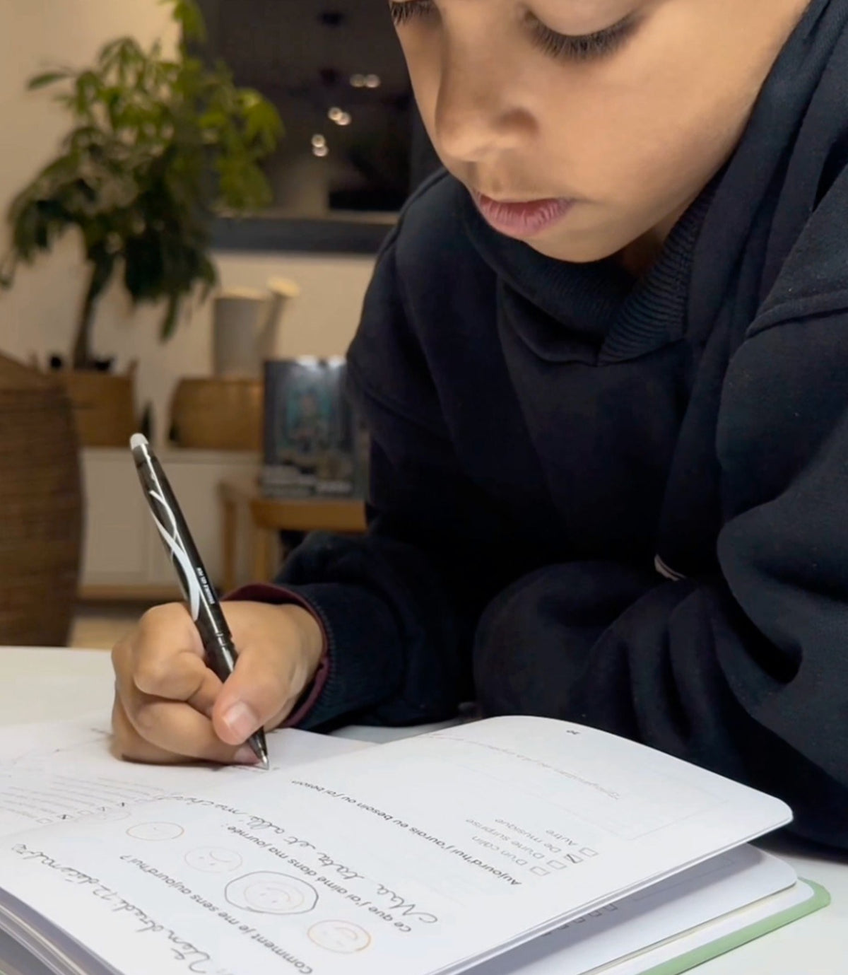 A boy writes in his journal in the evening