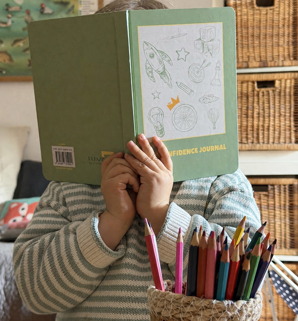 A child holds My Confidence Journal